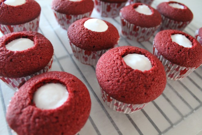 Piping the fluff into each cupcake.